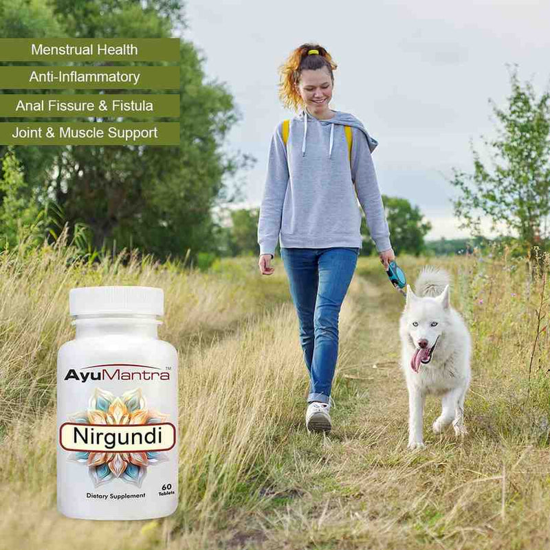 Woman walking a dog with an AyuMantra Nir Gundadi supplement bottle in the foreground.