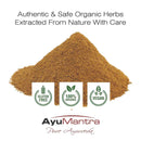 Pile of brown powder with AyuMantra branding and certification logos on a white background