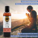Bottle of Pinda Organic Ayurvedic Oil with a person praying in a mountainous landscape.