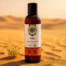 Bottle of 'Pitta' Organic Ayurvedic Oil with a desert background