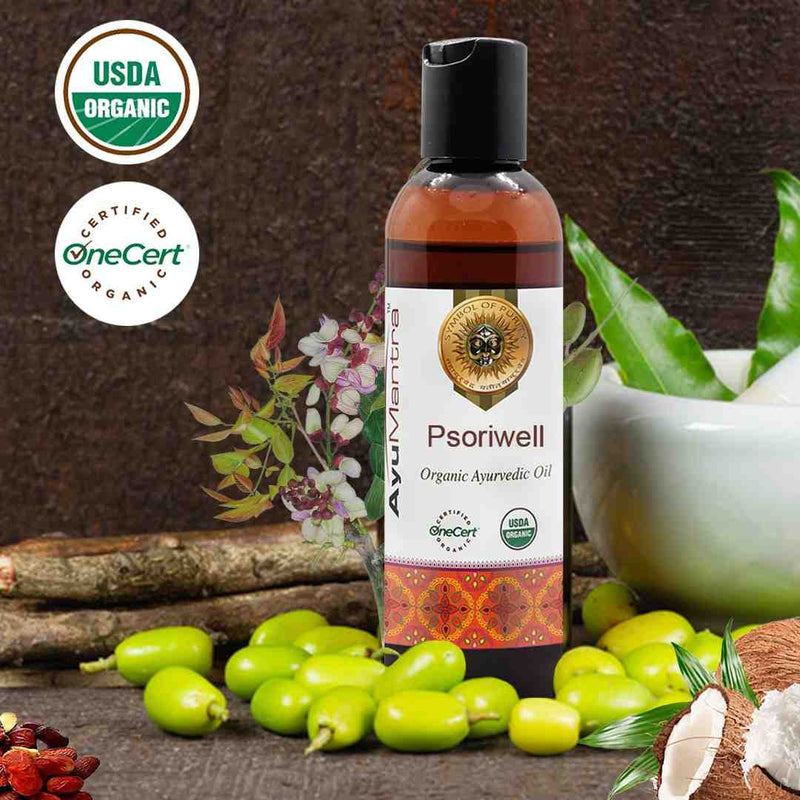 Bottle of Psorivell Organic Ayurvedic Oil with USDA Organic and OneCert Organic logos, surrounded by green leaves and a wooden background.