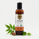 Bottle of Psoriwell organic ayurvedic oil with neem leaves and seeds on a white background
