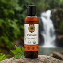 Bottle of Psoriwell Ayurvedic Oil with a natural background featuring a waterfall.