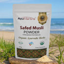 AyuMantra Safed Musli Powder packaging with a beach background