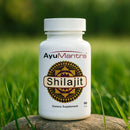 AyuMantra Shilajit pills bottle standing on grass, Ayurvedic dietary supplement for daily strength and vitality