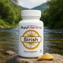AyuMantra Sirish tablets bottle on a river rock with herbal powder in front.