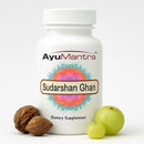 AyuMantra Sudarshan Ghan Vati tablets bottle with amla and haritaki fruits on a white background.