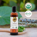 Bottle of AvuMandira Tridoshic Organic Ayurvedic Oil with USDA Organic and OneCert logos on a natural background.