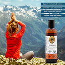 Person meditating with mountains in the background and a bottle of Tridoshic Ayurveda oil.