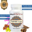 AyuMantra Triphala Guggul tablets bottle with 3x potency callouts and surrounding guggul, amla and long pepper.