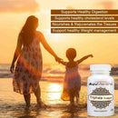 AyuMantra Triphala Guggul tablets bottle beside a mother and child walking on the beach at sunset.