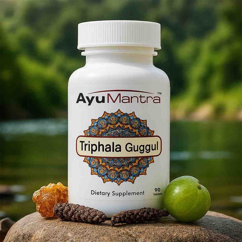 AyuMantra Triphala Guggul tablets bottle by riverside rock with guggul resin, long pepper and amla fruit.