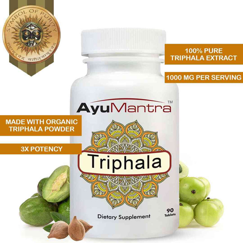AyuMantra Triphala tablets bottle with benefit highlights and fresh Triphala fruits at the base.