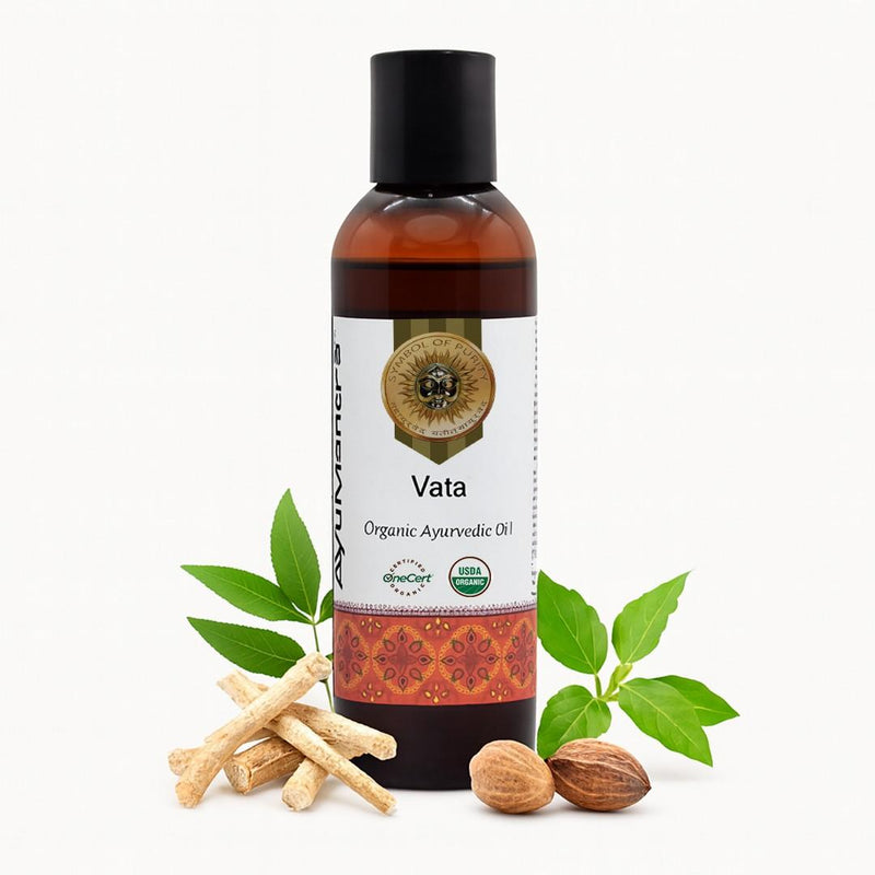 Bottle of Vata organic ayurvedic oil with leaves and nuts on a white background