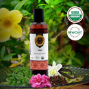 Bottle of Vata Organic Ayurvedic Oil with USDA Organic and OneCert Organic logos, surrounded by flowers and herbs.