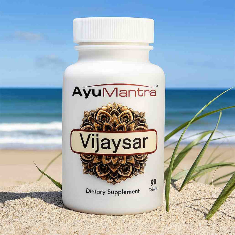 AyuMantra Vijaysar tablets bottle standing on beach sand with the ocean in background.