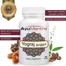 AyuMantra Yograj Guggul tablets bottle with purity badge, guggul resin and herbs around it