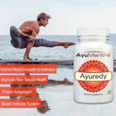Man doing yoga pose by the sea with Ayuredy tablets bottle highlighting strength and immune support.