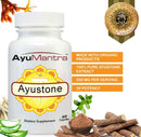Ayustone capsules bottle with organic herbs, roots, and purity badge shown around it.