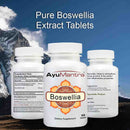 Three Ayumantra Boswellia tablets bottles showing front label and supplement facts with mountain sky background
