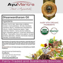 AyuMantra Dhaanwantharam Oil packaging with ingredients list, organic certification logos, and natural elements.