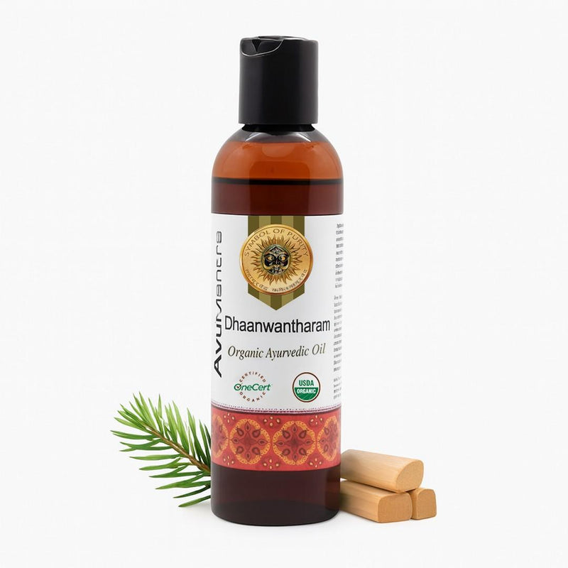 Bottle of Dhanwantharam Ayurvedic oil with a leaf and wooden sticks on a white background