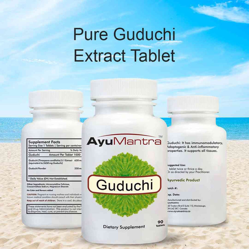 Three AyuMantra Guduchi tablets bottles front and back with pure guduchi extract text on beach