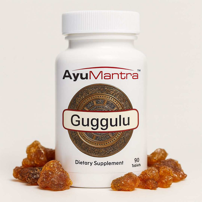Front view of AyuMantra Guggulu tablets bottle surrounded by guggul resin chunks on a light background.