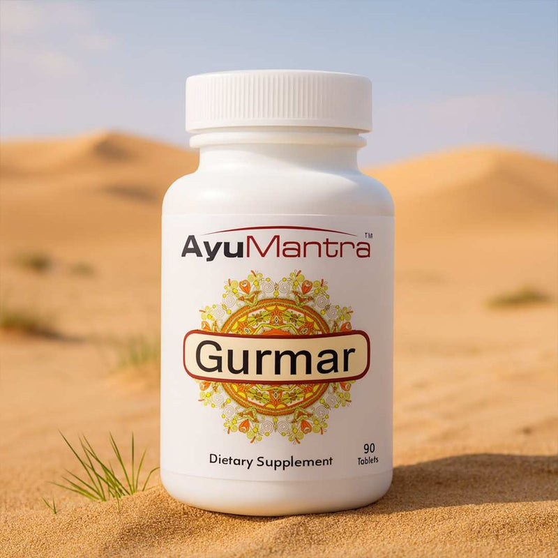 AyuMantra gurmar tablet bottle standing on desert sand as an Ayurvedic dietary supplement.