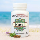 AyuMantra Kutki dietary supplement bottle on a beach with ocean in the background